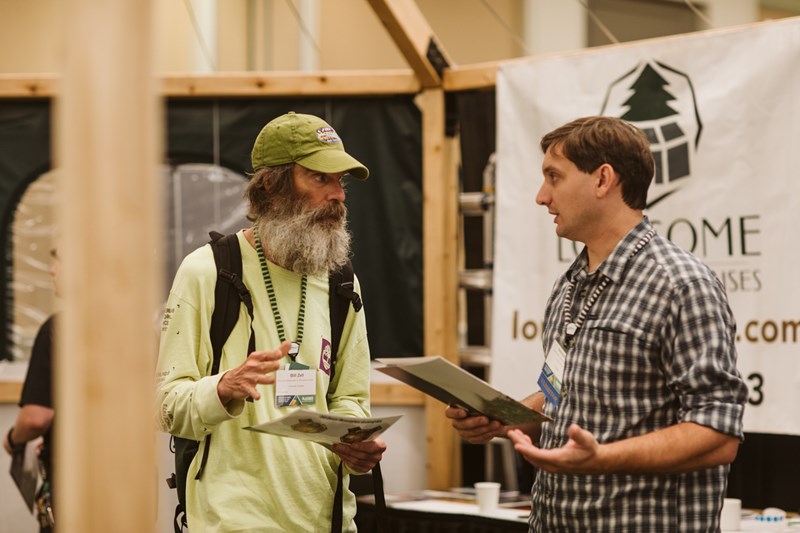 two men in a discussion in the expo hall 