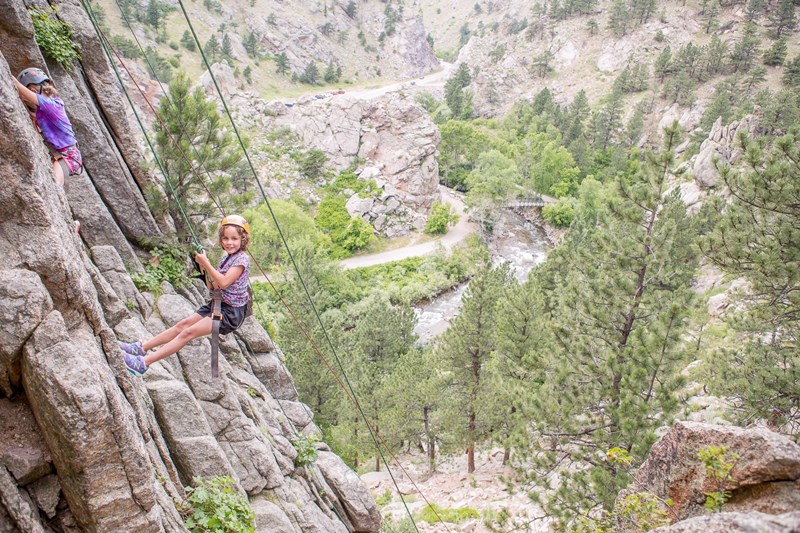 Two girls climbing on a rock face