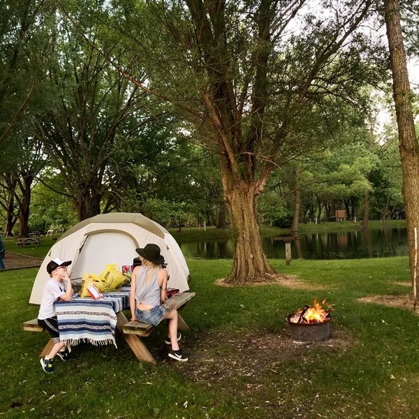 Woman and boy camping with fire in Mongo, Indiana