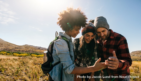 Group Of Young Hikers Looking At Pictures On Mobile Phone