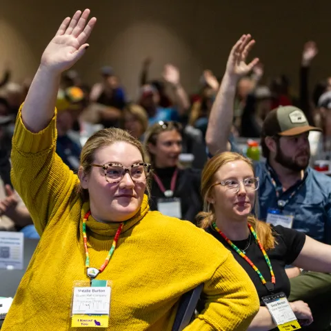 outdoor recreation professionals raise their hands at an america outdoors conference