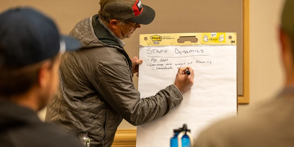 outfitter taking notes during a session at an america outdoors conference