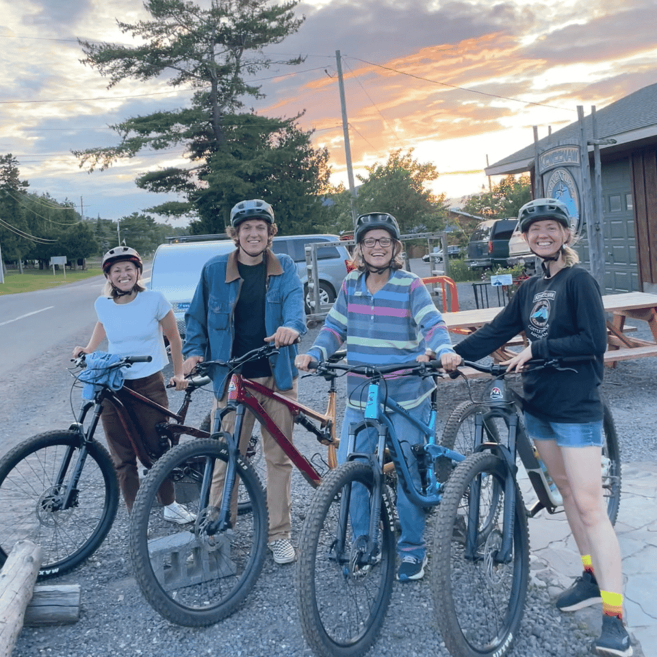 4 people standing next to bicycles