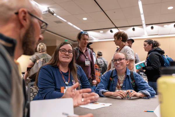 three people having a conversation at an america outdoors conference